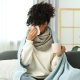 Cold symptom. Young woman with tissue and cup of hot drink at home